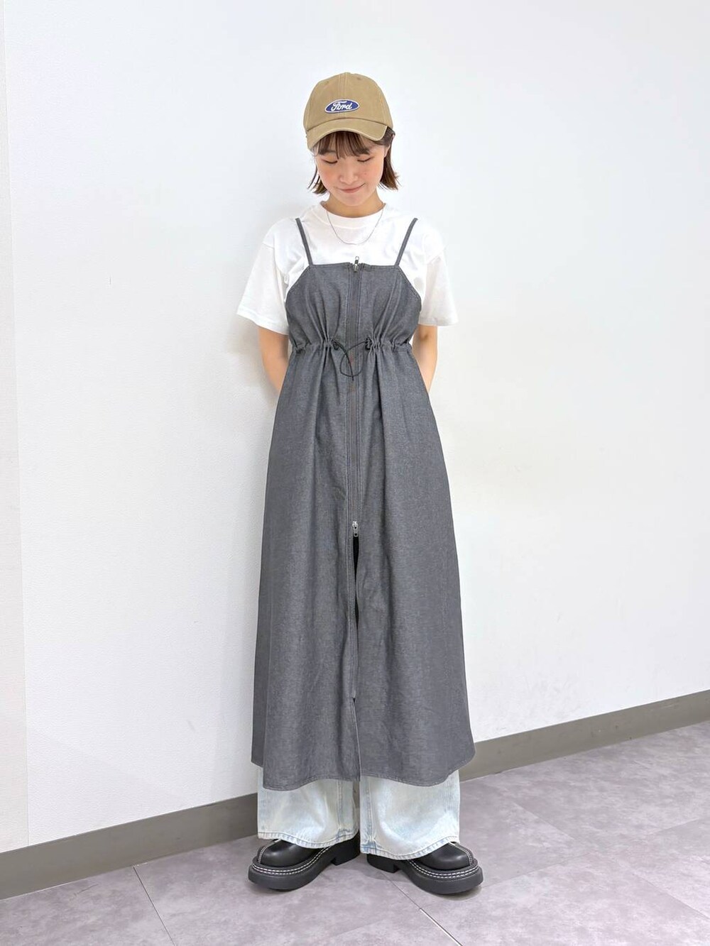 ブラック系のローファー、ブルー系のデニムパンツ、グレー系のワンピースを着用したレディースの春コーディネートの6枚目の写真