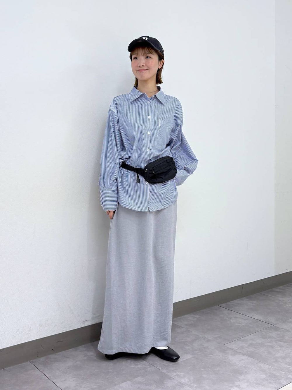 ブラック系のパンプス、ブラック系のボディバッグ/ウエストポーチ、ブルー系のシャツ/ブラウスを着用したレディースの春コーディネートの2枚目の写真