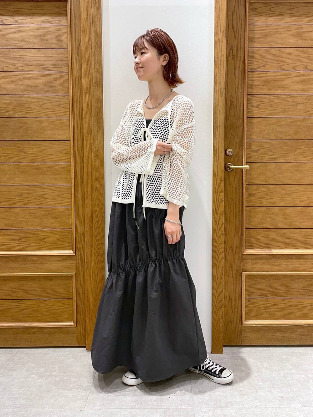 グレー系のスカート、ホワイト系のカーディガン/ボレロ、その他のブレスレットを着用したレディースの夏コーディネートの5枚目の写真