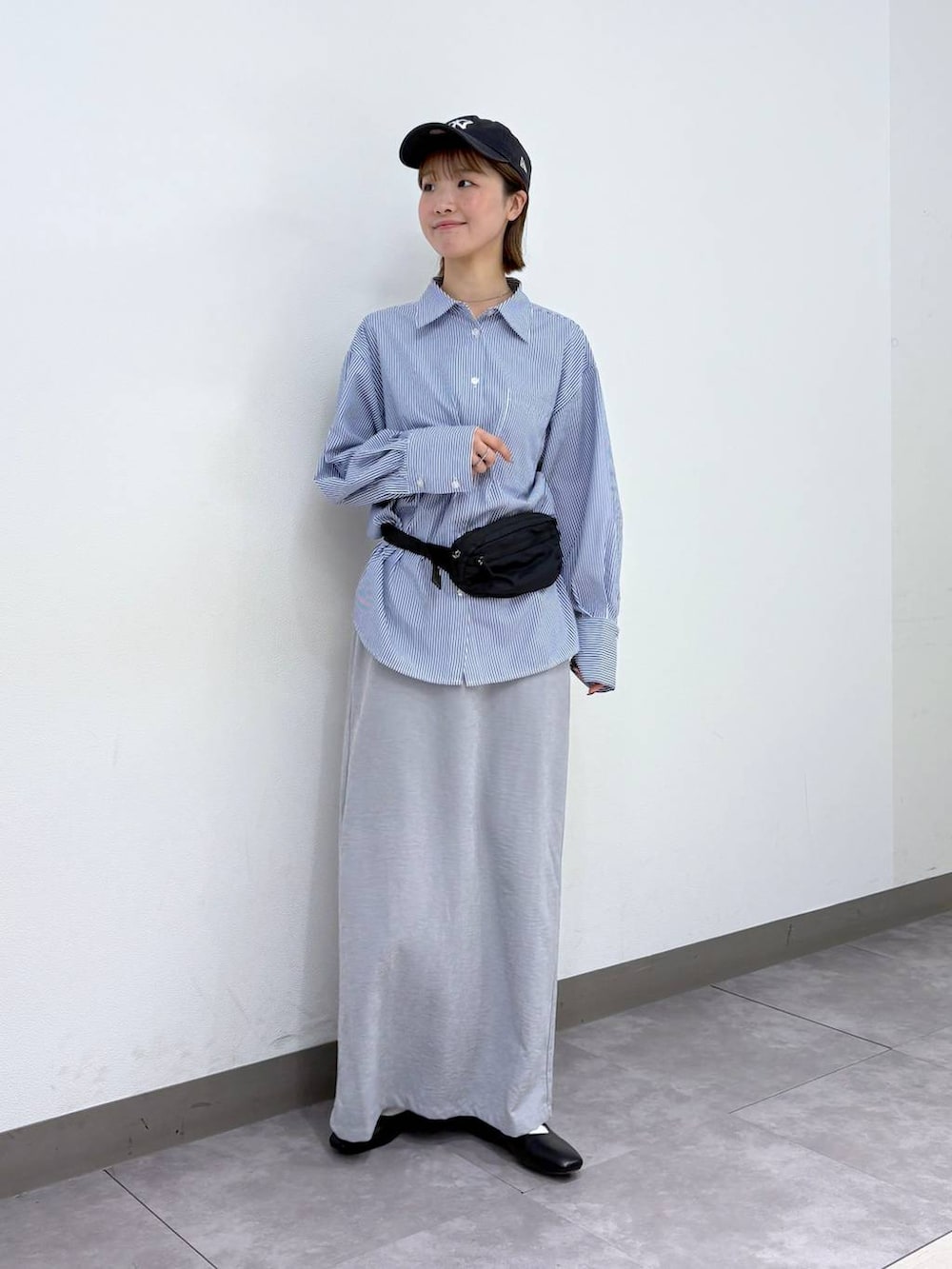 ブラック系のパンプス、ブラック系のボディバッグ/ウエストポーチ、ブルー系のシャツ/ブラウスを着用したレディースの春コーディネートの5枚目の写真