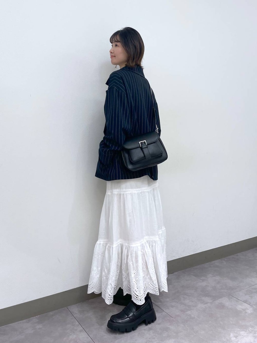 ブラック系のローファー、ブルー系のテーラードジャケット、ホワイト系のTシャツ/カットソーを着用したレディースの冬コーディネートの4枚目の写真