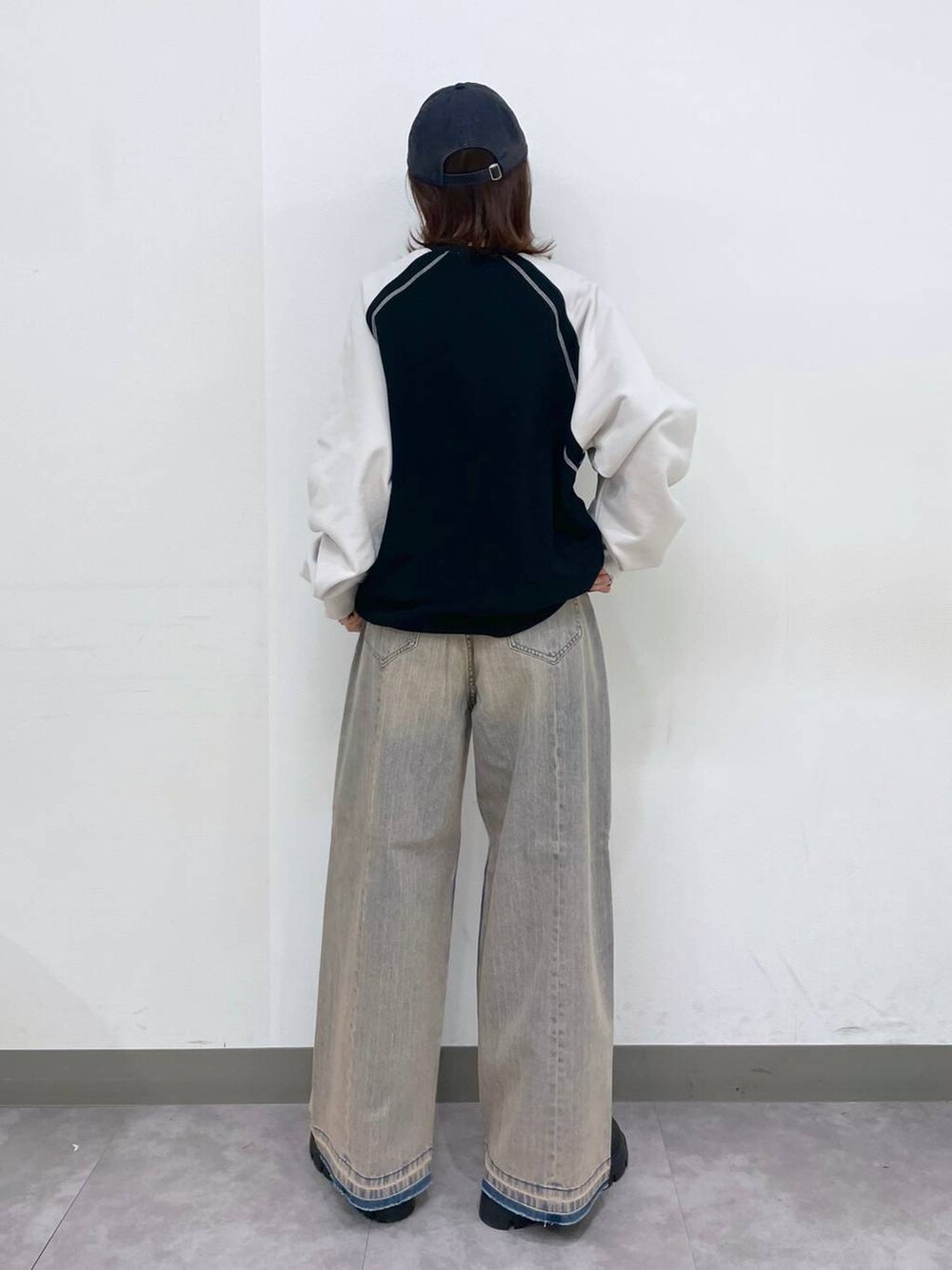 ブラック系のブーツ、ブラック系のスウェット、ブルー系のデニムパンツを着用したレディースの冬コーディネートの5枚目の写真