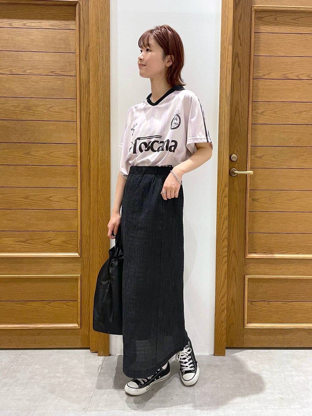 ブラック系のショルダーバッグ、ピンク系のTシャツ/カットソー、ブラック系のスカートを着用したレディースの夏コーディネートの4枚目の写真