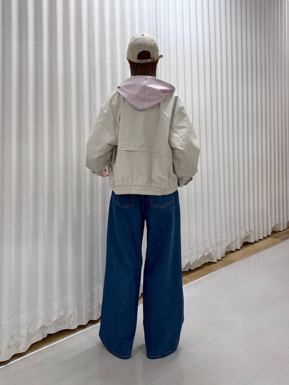 ブラック系のボディバッグ/ウエストポーチ、ブルー系のデニムパンツ、ベージュ系のブルゾンを着用したレディースの春コーディネートの4枚目の写真