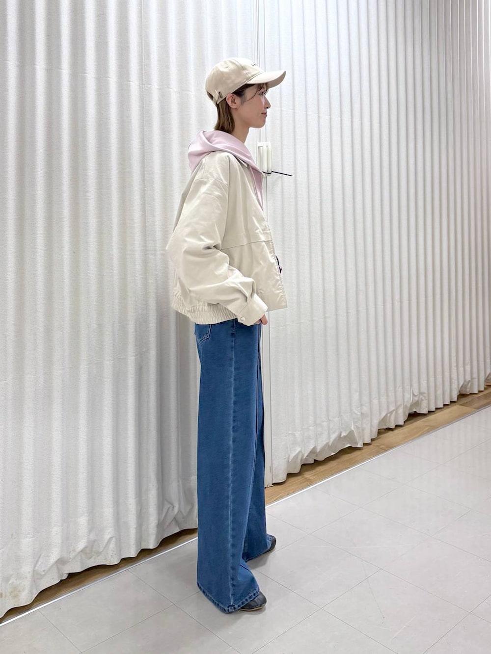 ブラック系のボディバッグ/ウエストポーチ、ブルー系のデニムパンツ、ベージュ系のブルゾンを着用したレディースの春コーディネートの5枚目の写真