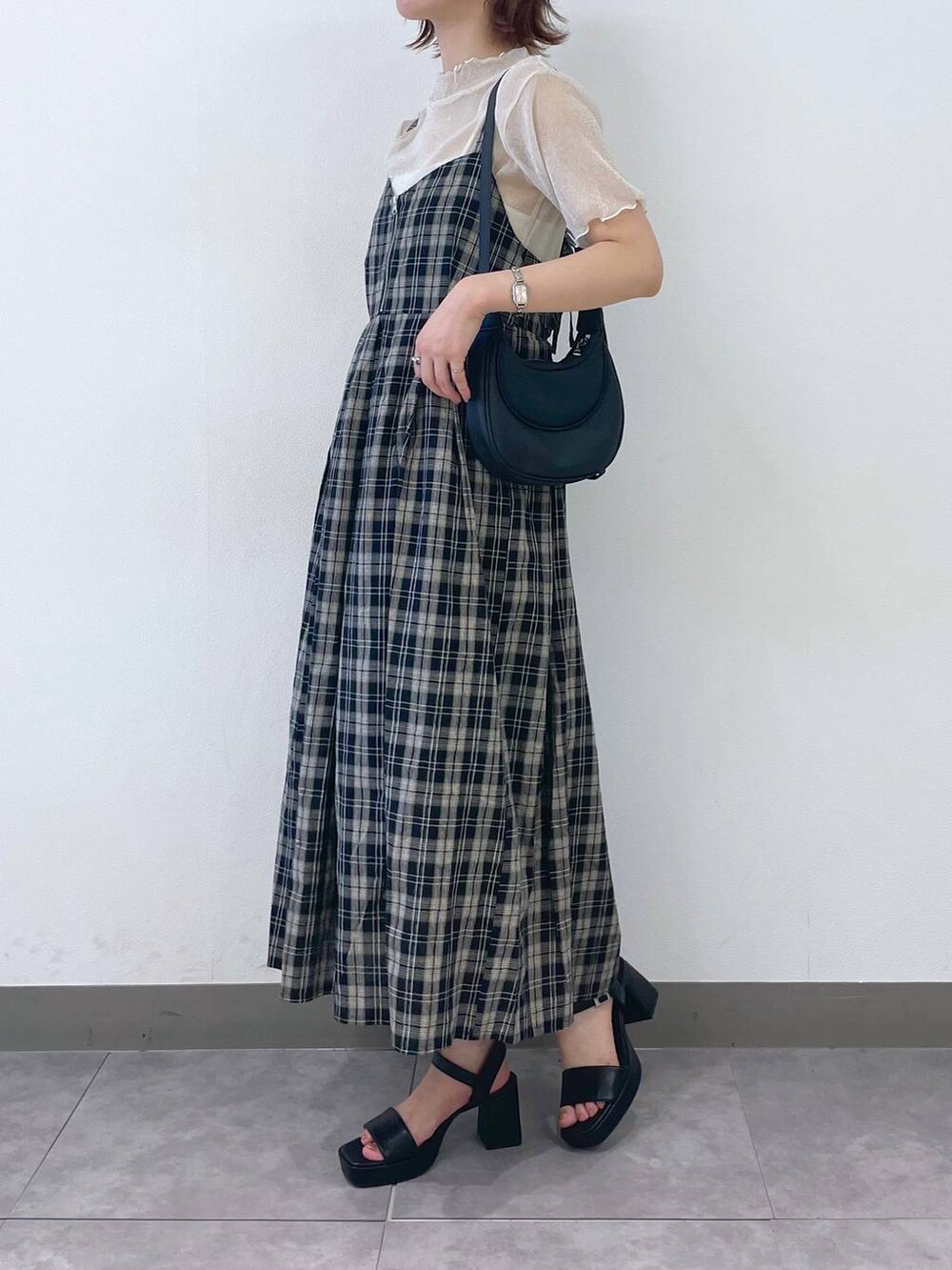 ブラック系のサンダル、ブラック系のワンピース、ホワイト系のキャミソールを着用したレディースの夏コーディネートの2枚目の写真