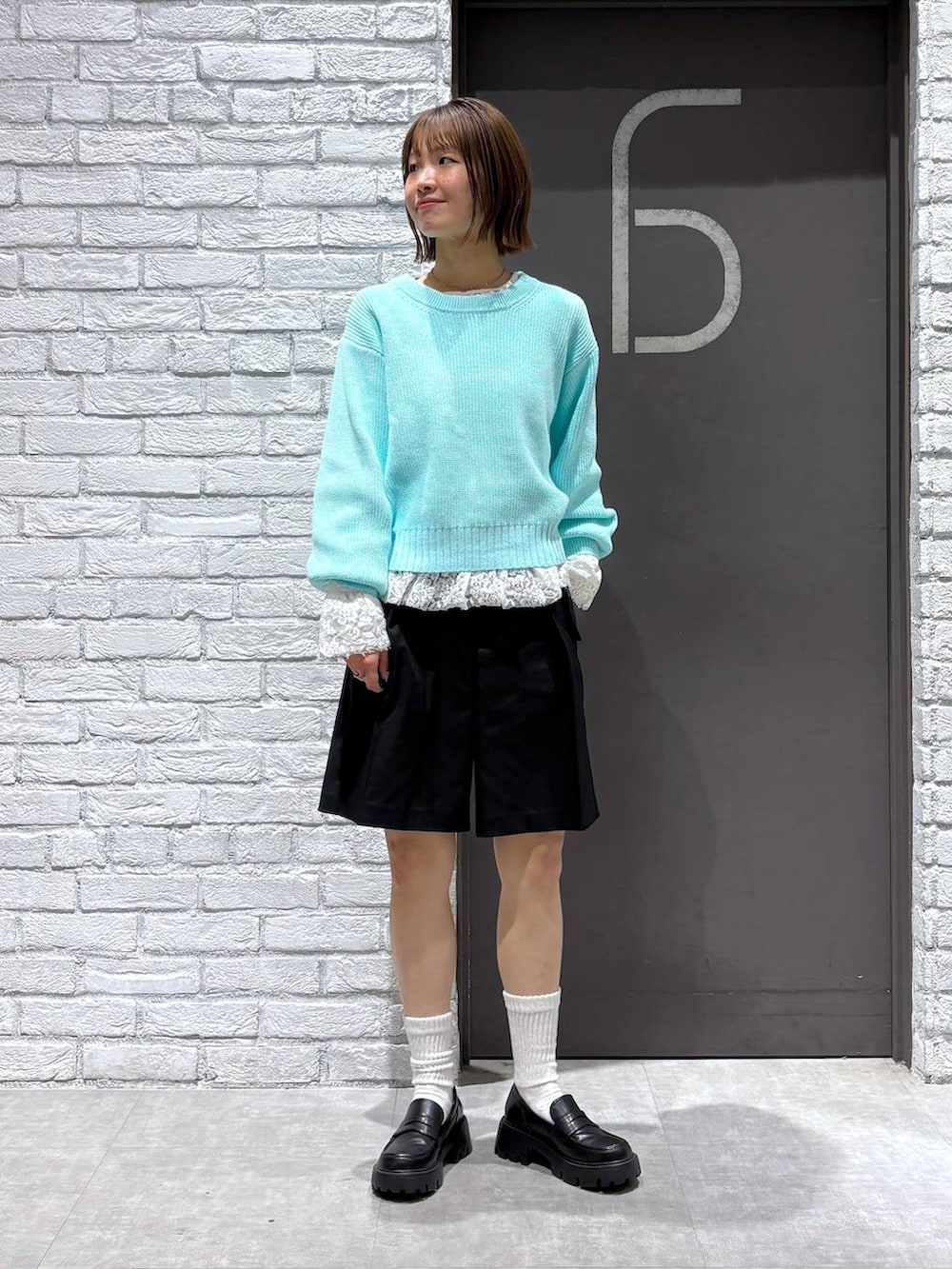 ブラック系のローファー、ブラック系のスラックス、ブルー系のニット/セーターを着用したレディースの冬コーディネートの6枚目の写真