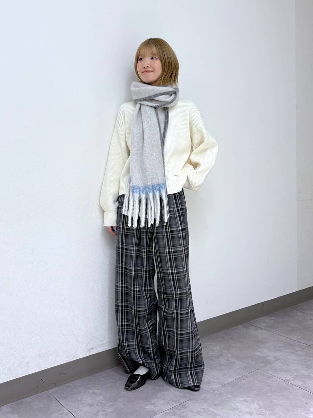 ホワイト系のニット/セーター、ブラック系のスラックス、ホワイト系のマフラーを着用したレディースの冬コーディネートの5枚目の写真