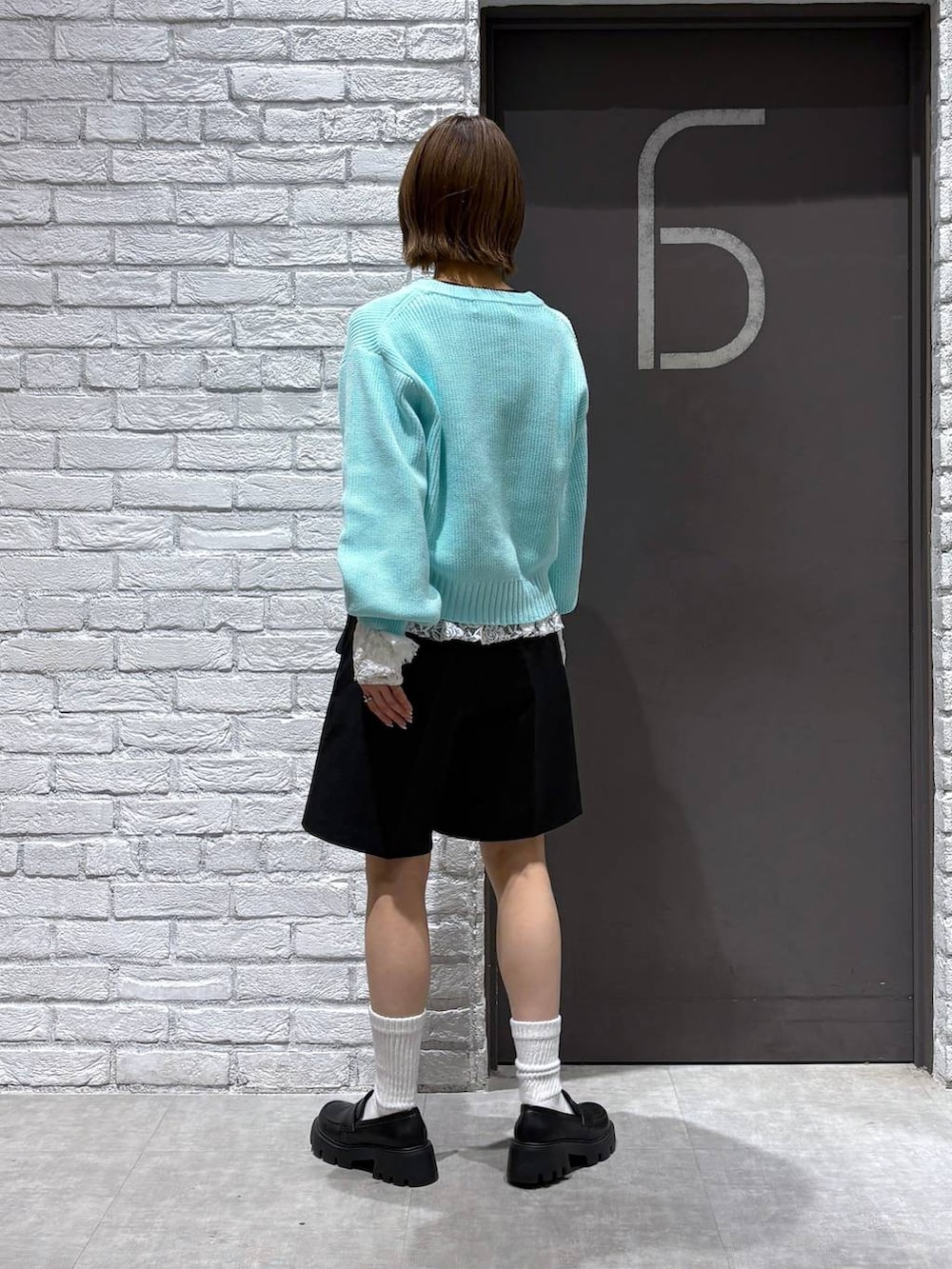 ブラック系のローファー、ブラック系のスラックス、ブルー系のニット/セーターを着用したレディースの冬コーディネートの5枚目の写真