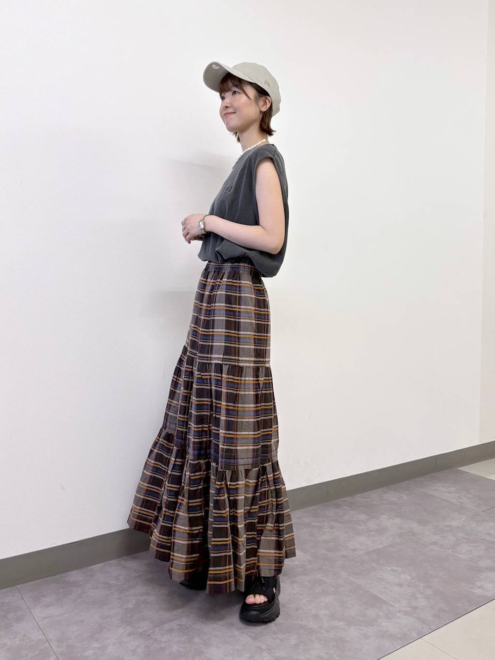 ブラック系のサンダル、ブラウン系のスカート、ブラック系のTシャツ/カットソーを着用したレディースの夏コーディネートの3枚目の写真