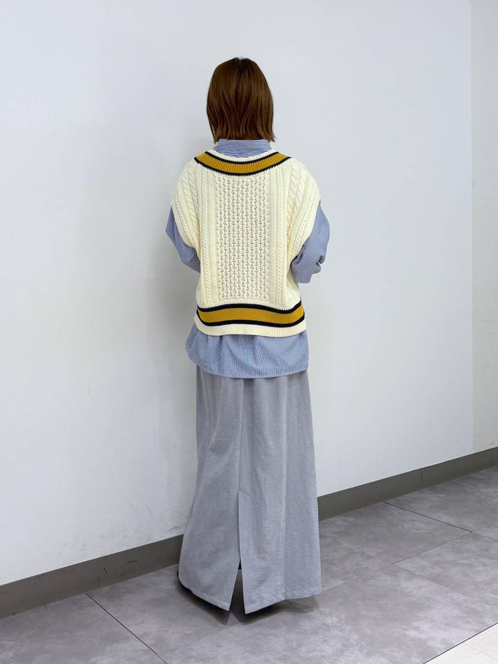 ブラック系のパンプス、ブルー系のシャツ/ブラウス、ホワイト系のベストを着用したレディースの春コーディネートの4枚目の写真