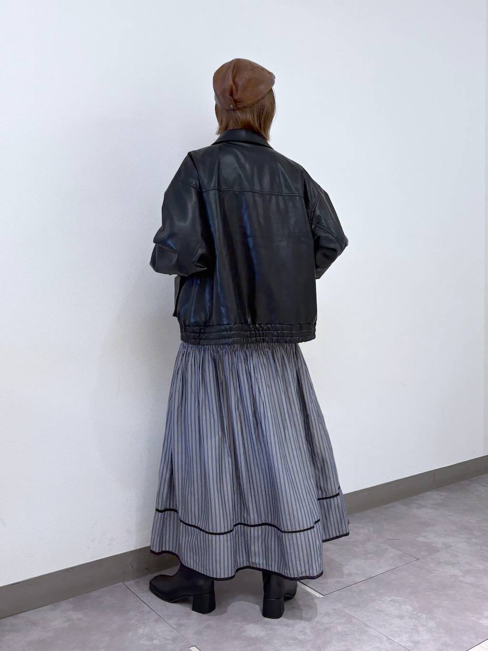 グレー系のスカート、ブラック系のブルゾン、ブルー系のニット/セーターを着用したレディースの冬コーディネートの3枚目の写真