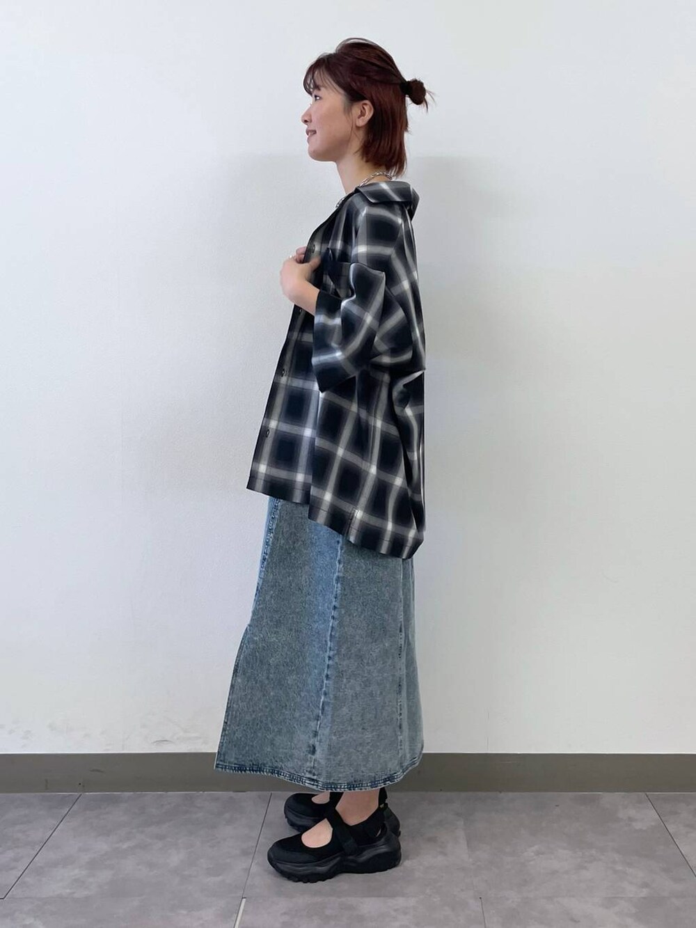 ブラック系のスニーカー、ブルー系のワンピース、シルバー系のブレスレットを着用したレディースの夏コーディネートの4枚目の写真