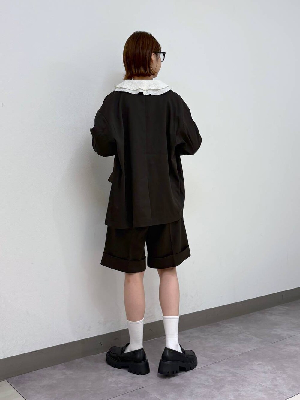 ブラック系のローファー、ホワイト系のシャツ/ブラウス、ブラウン系のスラックスを着用したレディースの夏コーディネートの5枚目の写真