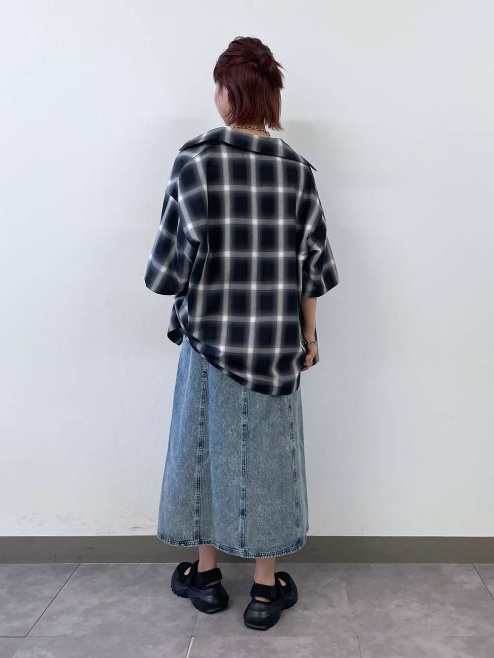 ブラック系のスニーカー、ブルー系のワンピース、シルバー系のブレスレットを着用したレディースの夏コーディネートの5枚目の写真