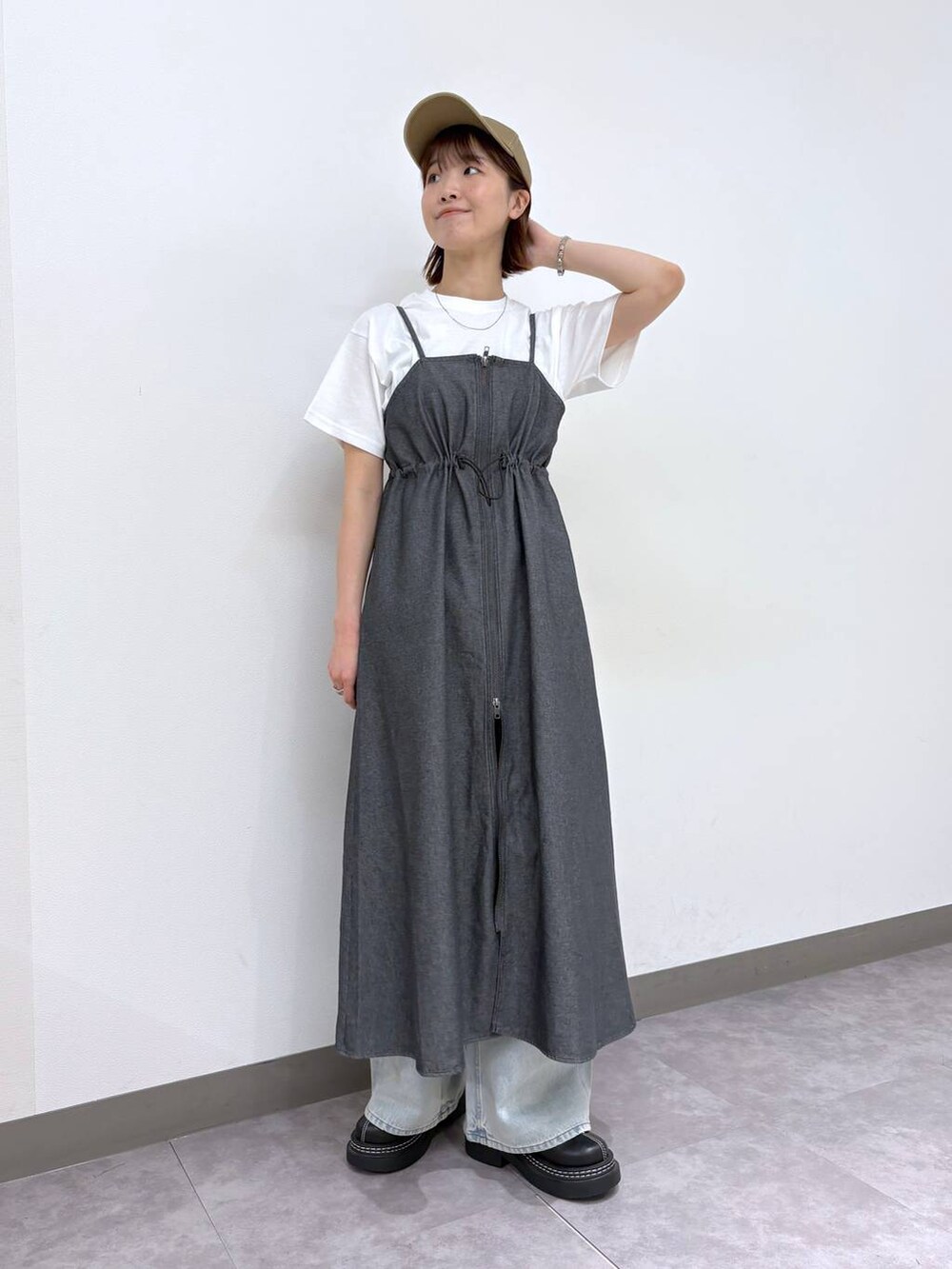 ブラック系のローファー、ブルー系のデニムパンツ、グレー系のワンピースを着用したレディースの春コーディネートの7枚目の写真