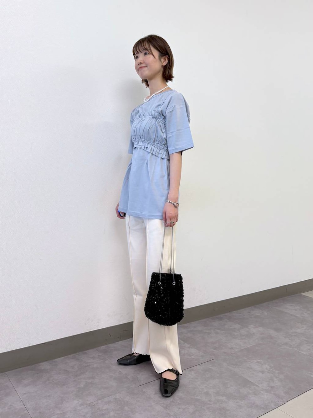 ブルー系のTシャツ/カットソー、ホワイト系のスウェットパンツ、ブラック系のハンドバッグを着用したレディースの夏コーディネートの2枚目の写真