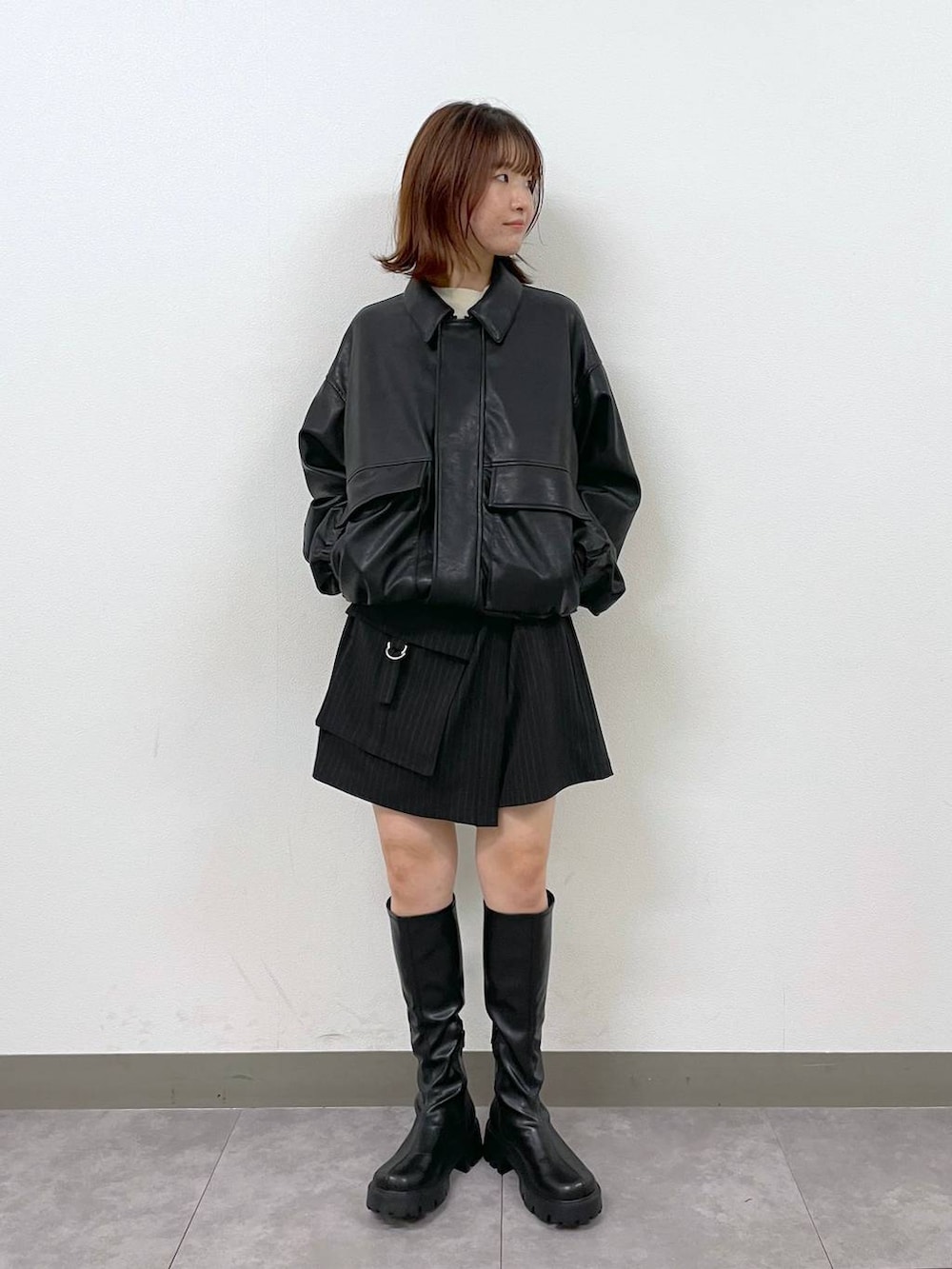 ブラック系のブルゾン、ブラック系のブーツ、ブラック系のスカートを着用したレディースの秋コーディネートの2枚目の写真