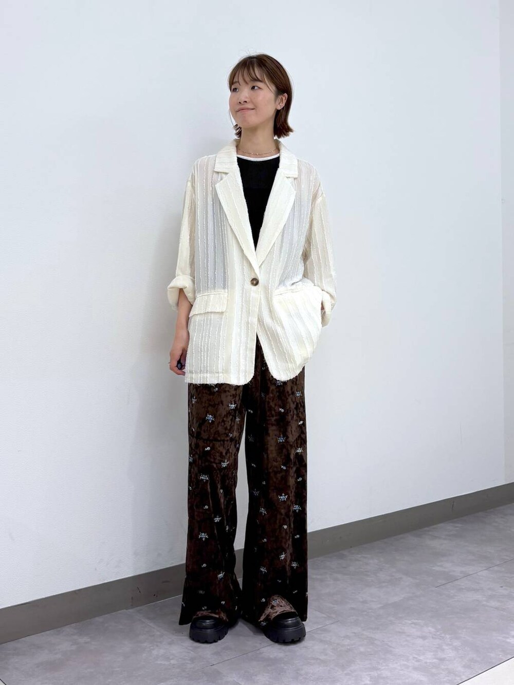 ブラック系のローファー、ホワイト系のテーラードジャケット、ブラウン系のスウェットパンツを着用したレディースの夏コーディネートの6枚目の写真