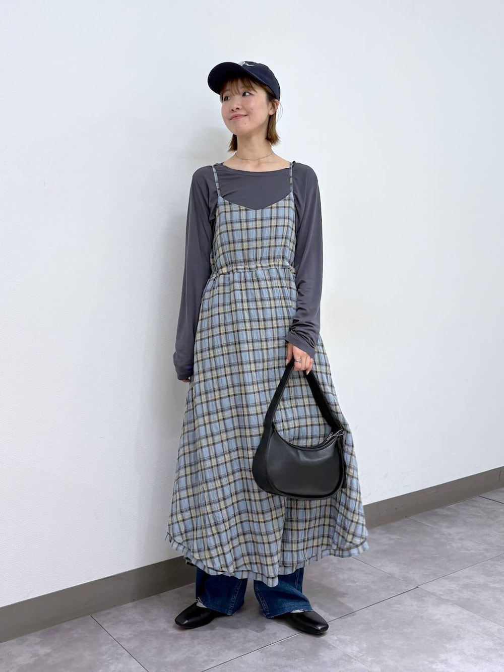 ブラック系のパンプス、ブルー系のデニムパンツ、ブラック系のショルダーバッグを着用したレディースの春コーディネートの2枚目の写真