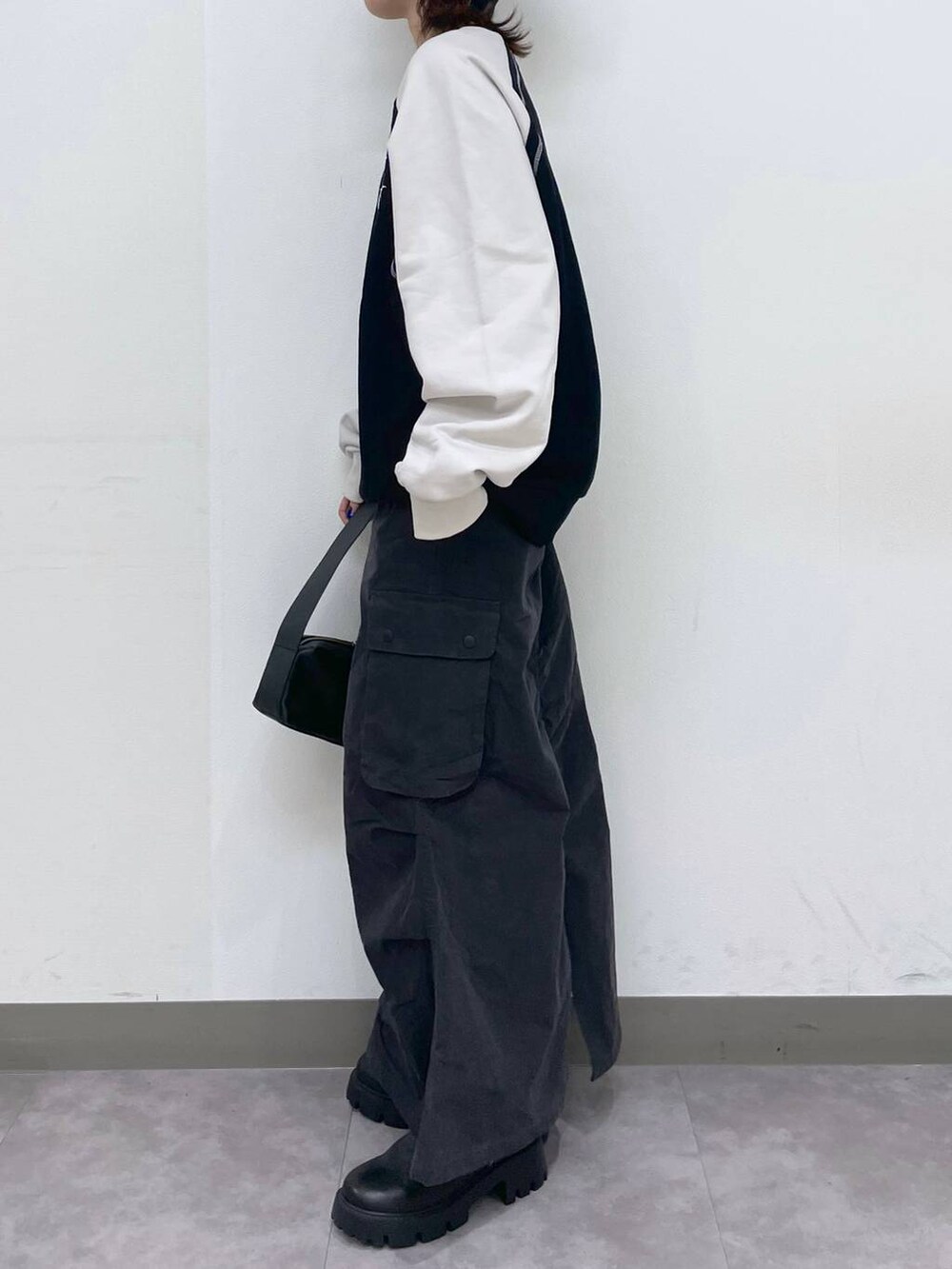 ブラック系のブーツ、ブラック系のショルダーバッグ、ブラック系のスウェットを着用したレディースの冬コーディネートの3枚目の写真