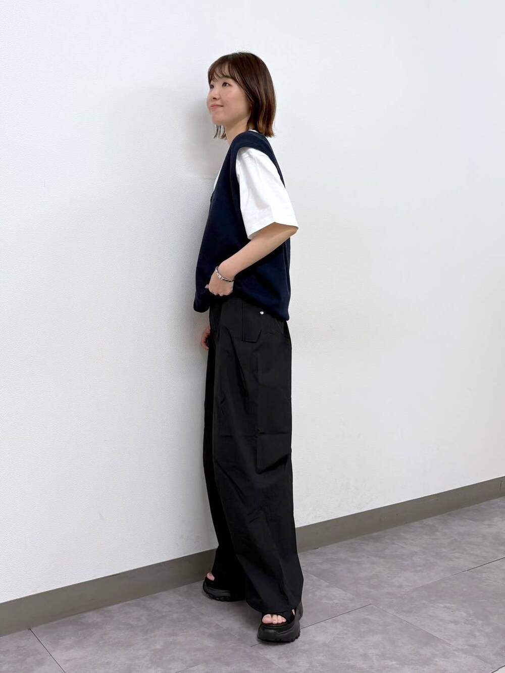 ホワイト系のTシャツ/カットソー、ブラック系のサンダル、ブラック系のカーゴパンツを着用したレディースの春コーディネートの2枚目の写真