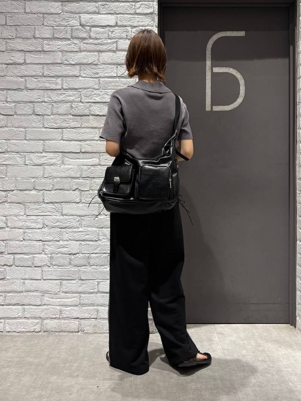 グレー系のニット/セーター、ブラック系のスウェットパンツ、ブラック系のショルダーバッグを着用したレディースの夏コーディネートの4枚目の写真