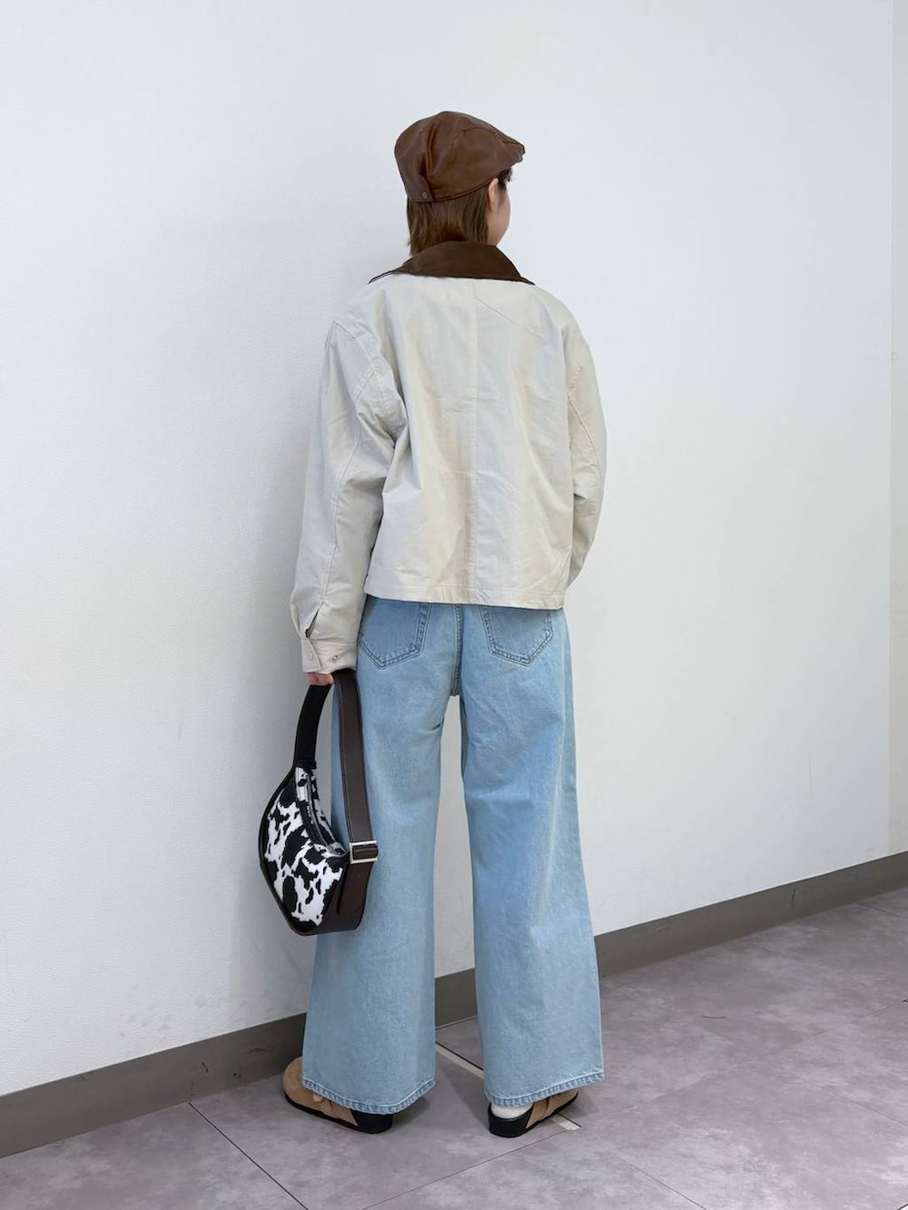 ブルー系のデニムパンツ、ピンク系のカーディガン/ボレロ、ブラウン系のショルダーバッグを着用したレディースの冬コーディネートの4枚目の写真