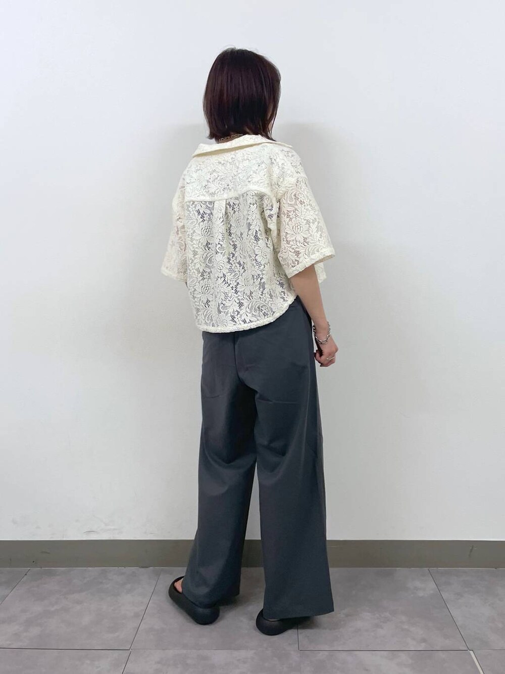 グレー系のスラックス、ホワイト系のシャツ/ブラウス、シルバー系のブレスレットを着用したレディースの夏コーディネートの3枚目の写真