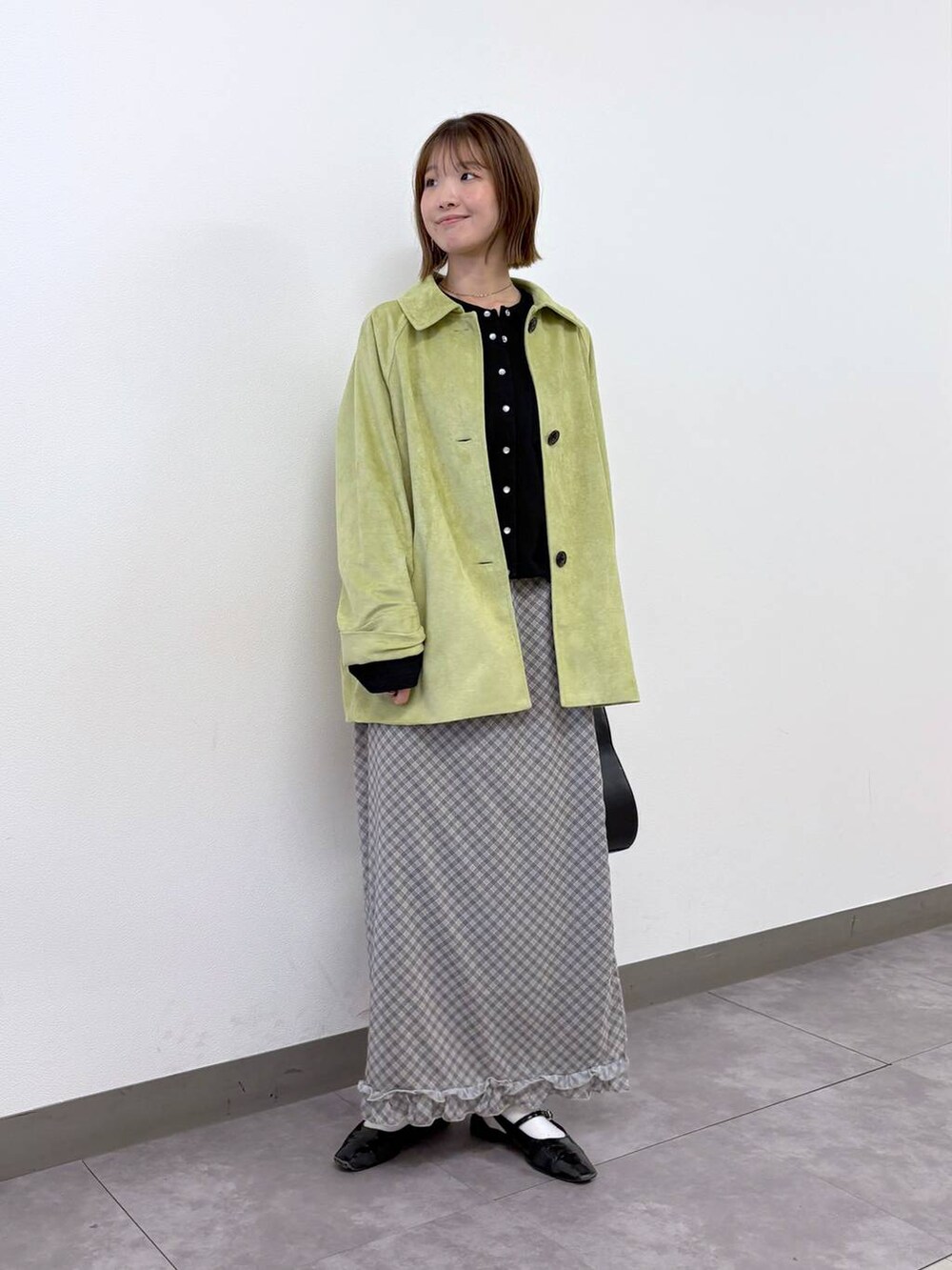 ブラック系のカーディガン/ボレロ、ブラック系のショルダーバッグ、グリーン系のブルゾンを着用したレディースの春コーディネートの5枚目の写真