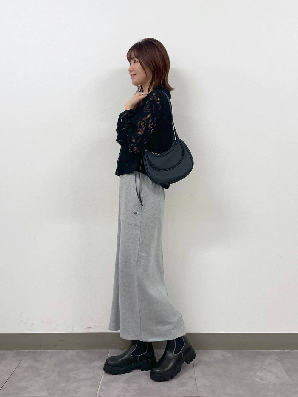 ブラック系のショルダーバッグ、ブラック系のシャツ/ブラウス、ブラック系のブーツを着用したレディースの秋コーディネートの3枚目の写真