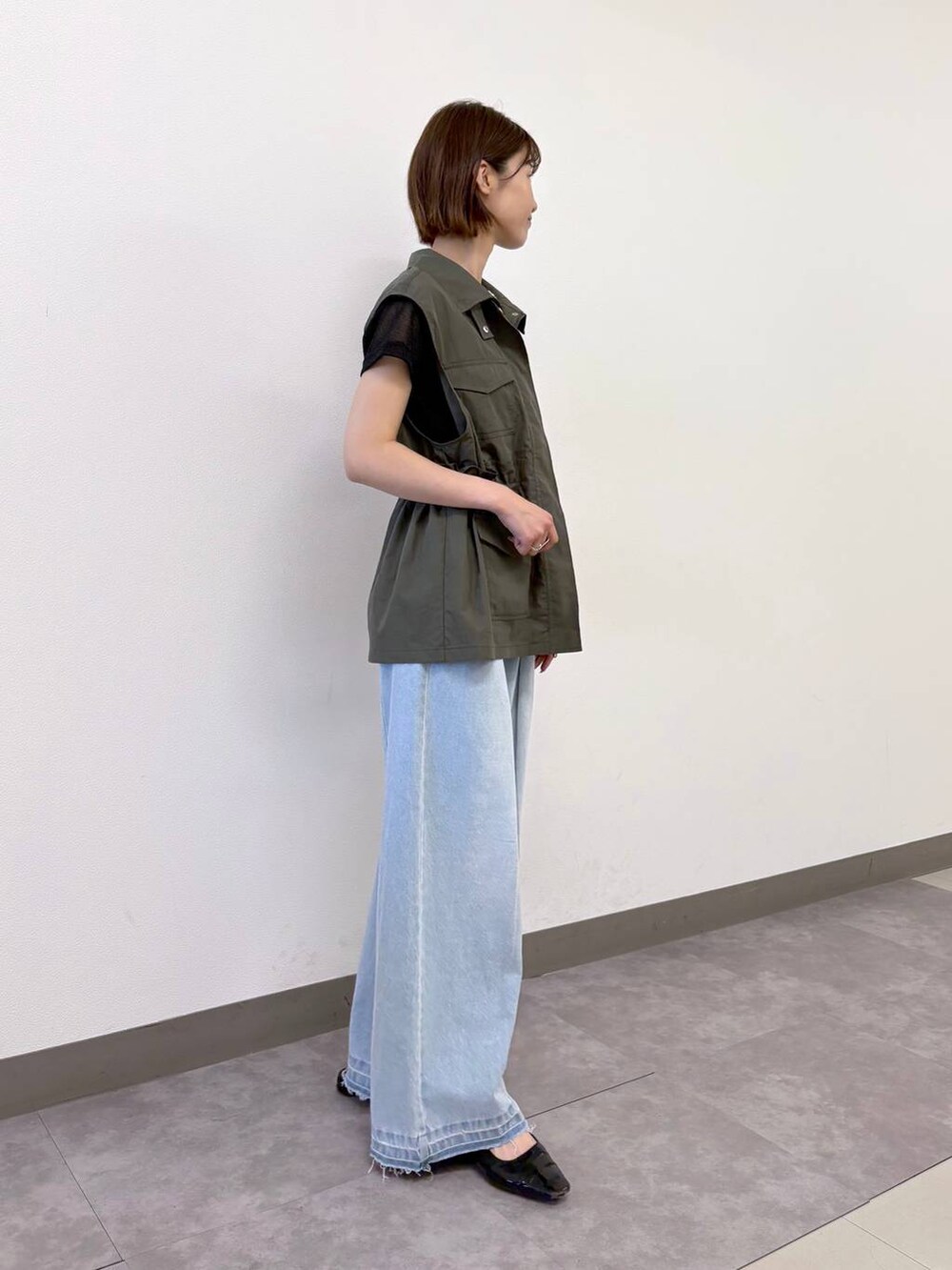 ブラック系のTシャツ/カットソー、ブルー系のデニムパンツ、グリーン系のベストを着用したレディースの夏コーディネートの5枚目の写真