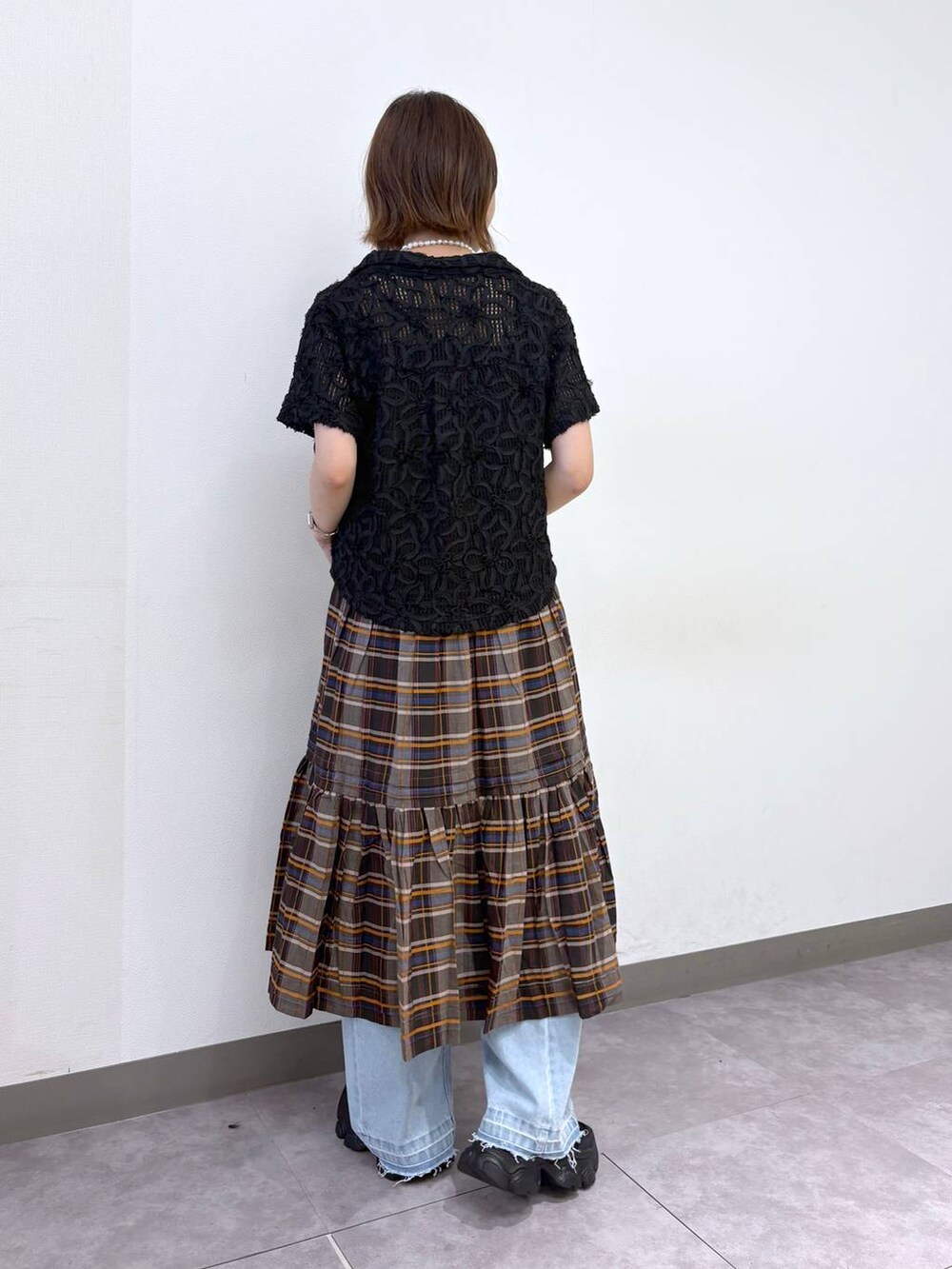 ブラック系のサンダル、ブルー系のデニムパンツ、ブラック系のシャツ/ブラウスを着用したレディースの夏コーディネートの3枚目の写真