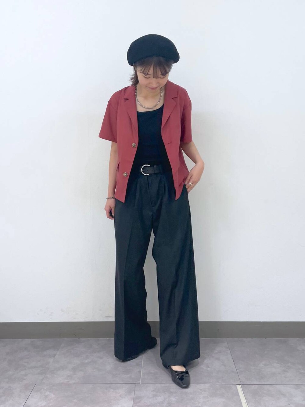 ブラック系のスラックス、レッド系のシャツ/ブラウス、その他のブレスレットを着用したレディースの夏コーディネートの2枚目の写真