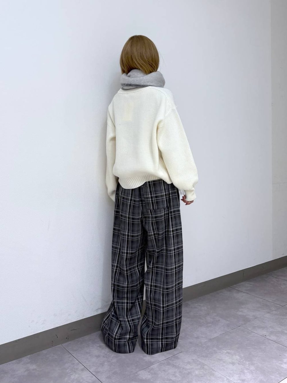 ホワイト系のニット/セーター、ブラック系のスラックス、ホワイト系のマフラーを着用したレディースの冬コーディネートの4枚目の写真