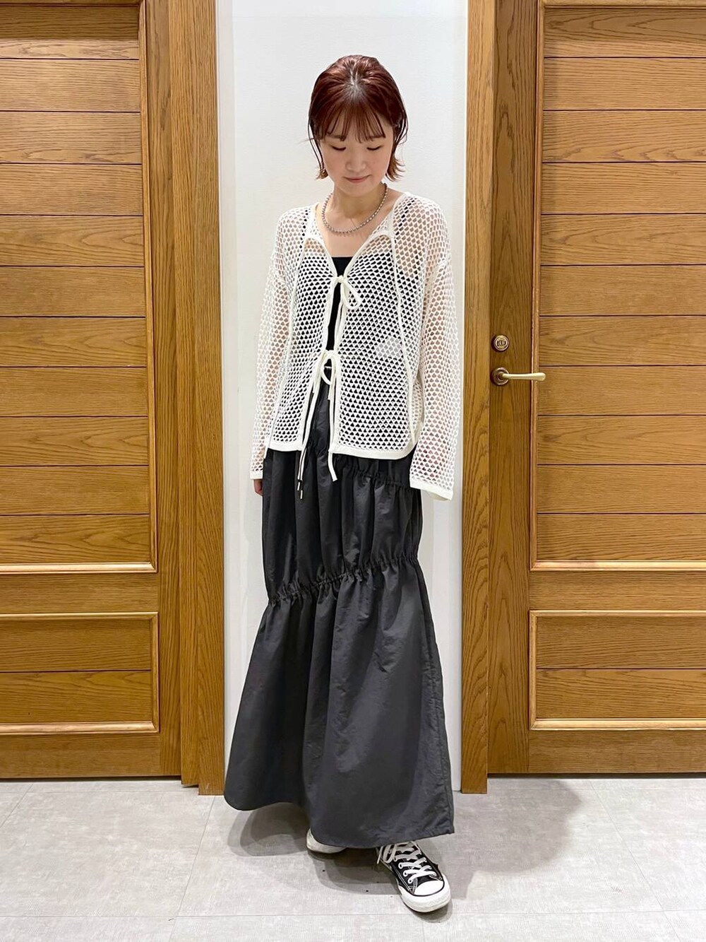 グレー系のスカート、ホワイト系のカーディガン/ボレロ、その他のブレスレットを着用したレディースの夏コーディネートの2枚目の写真