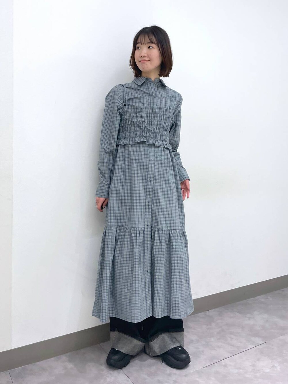 ブラック系のスニーカー、ブルー系のシャツワンピース、ブラック系のデニムパンツを着用したレディースの春コーディネートの6枚目の写真