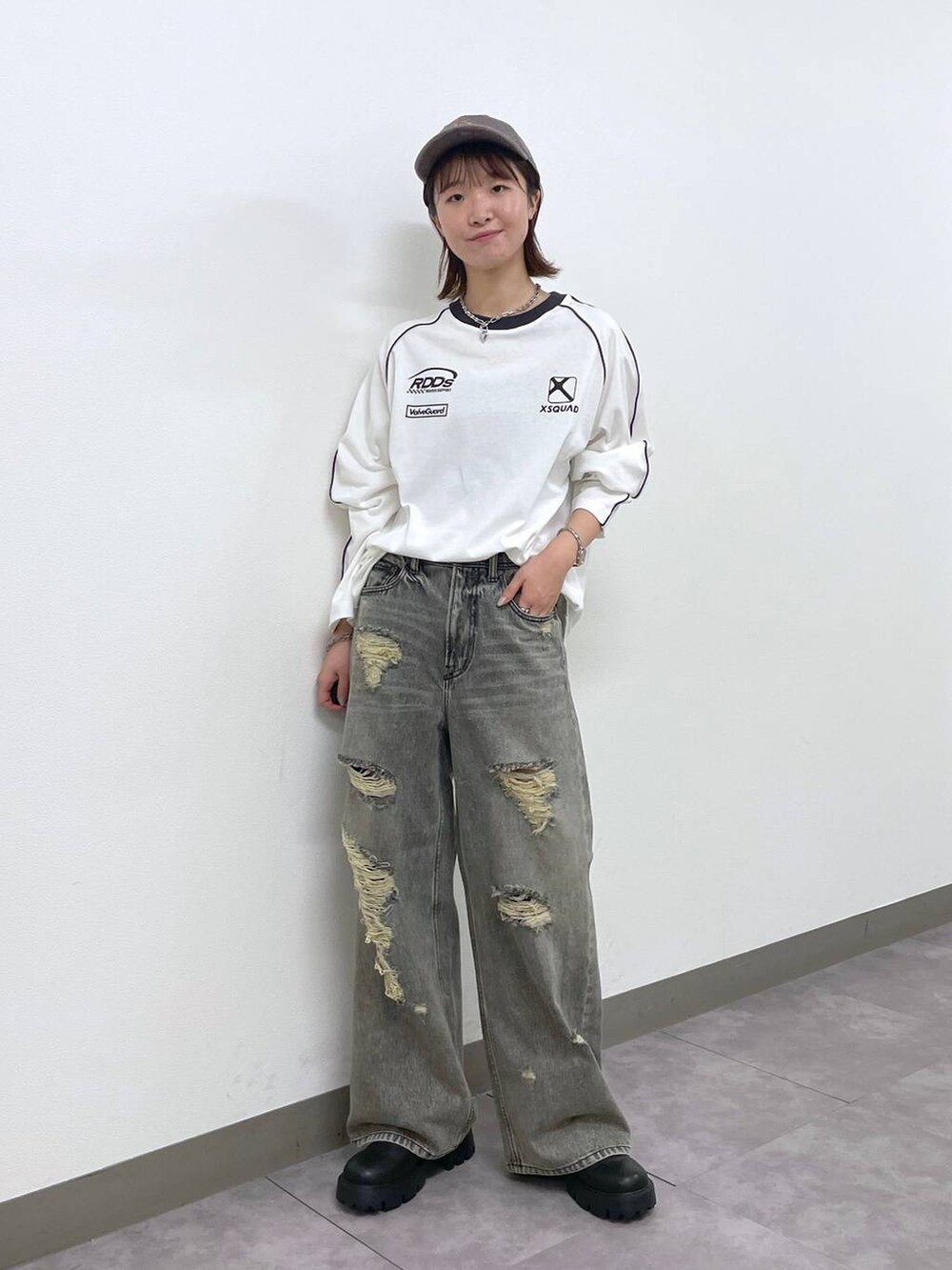 ブラック系のデニムパンツ、ブラック系のブーツ、ホワイト系のTシャツ/カットソーを着用したレディースの秋コーディネートの5枚目の写真