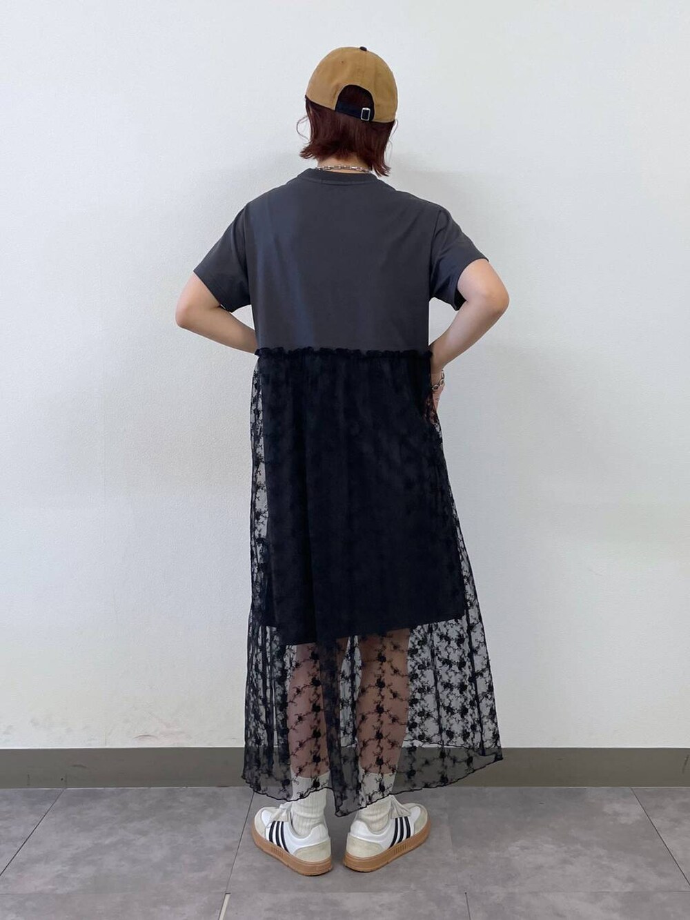 グレー系のワンピース、ブルー系のキャップ、シルバー系のブレスレットを着用したレディースの夏コーディネートの4枚目の写真