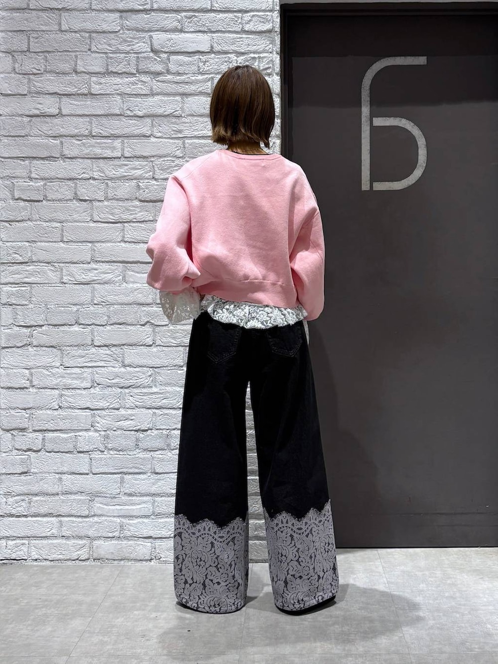 ピンク系のカーディガン/ボレロ、ブラック系のデニムパンツ、ブラック系のモカシン/デッキシューズを着用したレディースの冬コーディネートの3枚目の写真