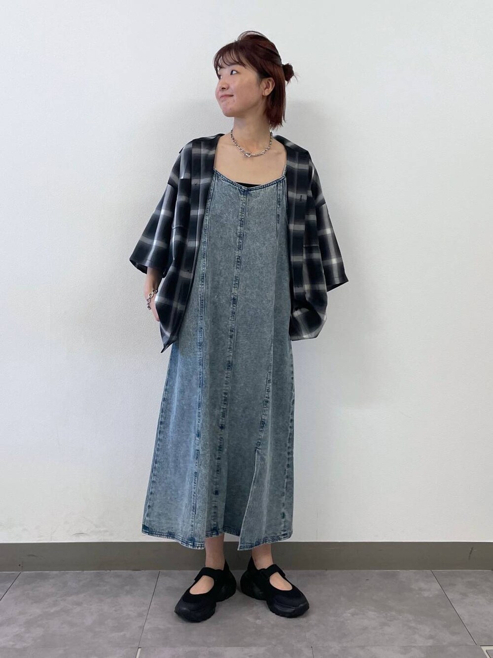 ブラック系のスニーカー、ブルー系のワンピース、シルバー系のブレスレットを着用したレディースの夏コーディネートの2枚目の写真