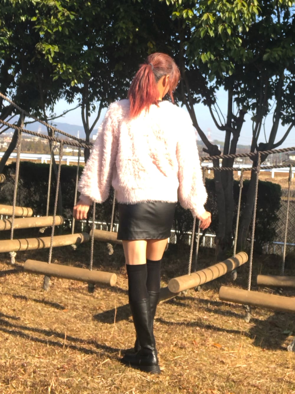 ブラック系のスカート、ブラック系のブーツ、ピンク系のニット/セーターを着用したメンズの冬コーディネートの2枚目の写真