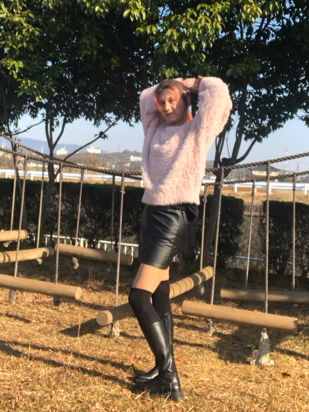 ブラック系のスカート、ブラック系のブーツ、ピンク系のニット/セーターを着用したメンズの冬コーディネートの4枚目の写真