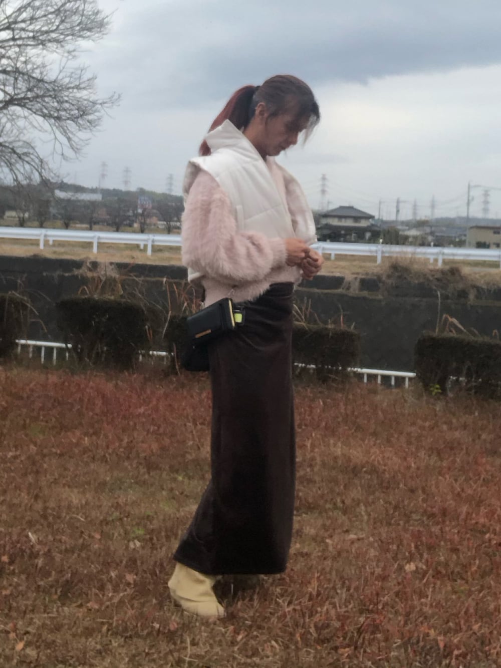 ブラック系のスカート、ベージュ系のブーツ、ピンク系のニット/セーターを着用したメンズの冬コーディネートの3枚目の写真