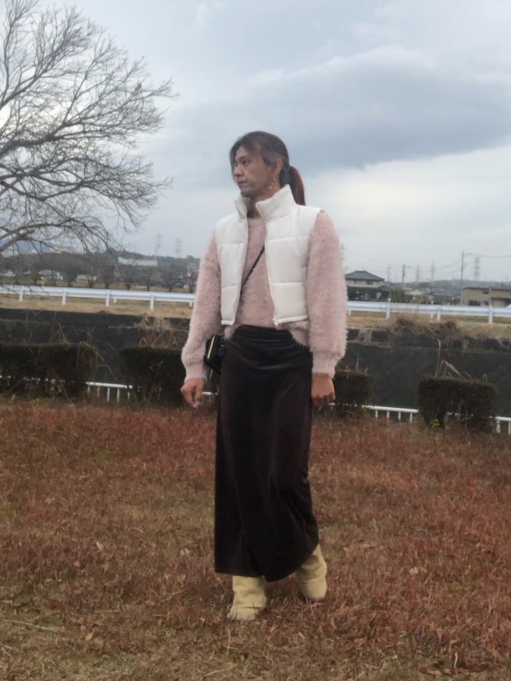 ブラック系のスカート、ベージュ系のブーツ、ピンク系のニット/セーターを着用したメンズの冬コーディネートの2枚目の写真