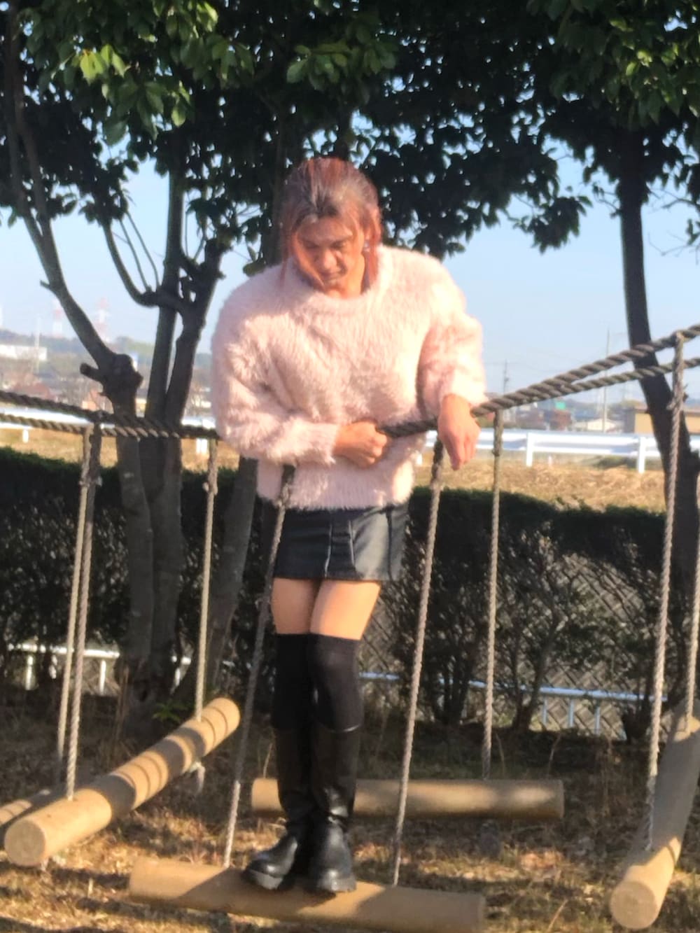 ブラック系のスカート、ブラック系のブーツ、ピンク系のニット/セーターを着用したメンズの冬コーディネートの5枚目の写真