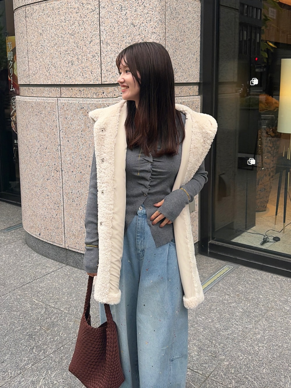 ホワイト系のベスト、ブルー系のその他パンツ、ブラウン系のトートバッグを着用したレディースの秋コーディネートの3枚目の写真