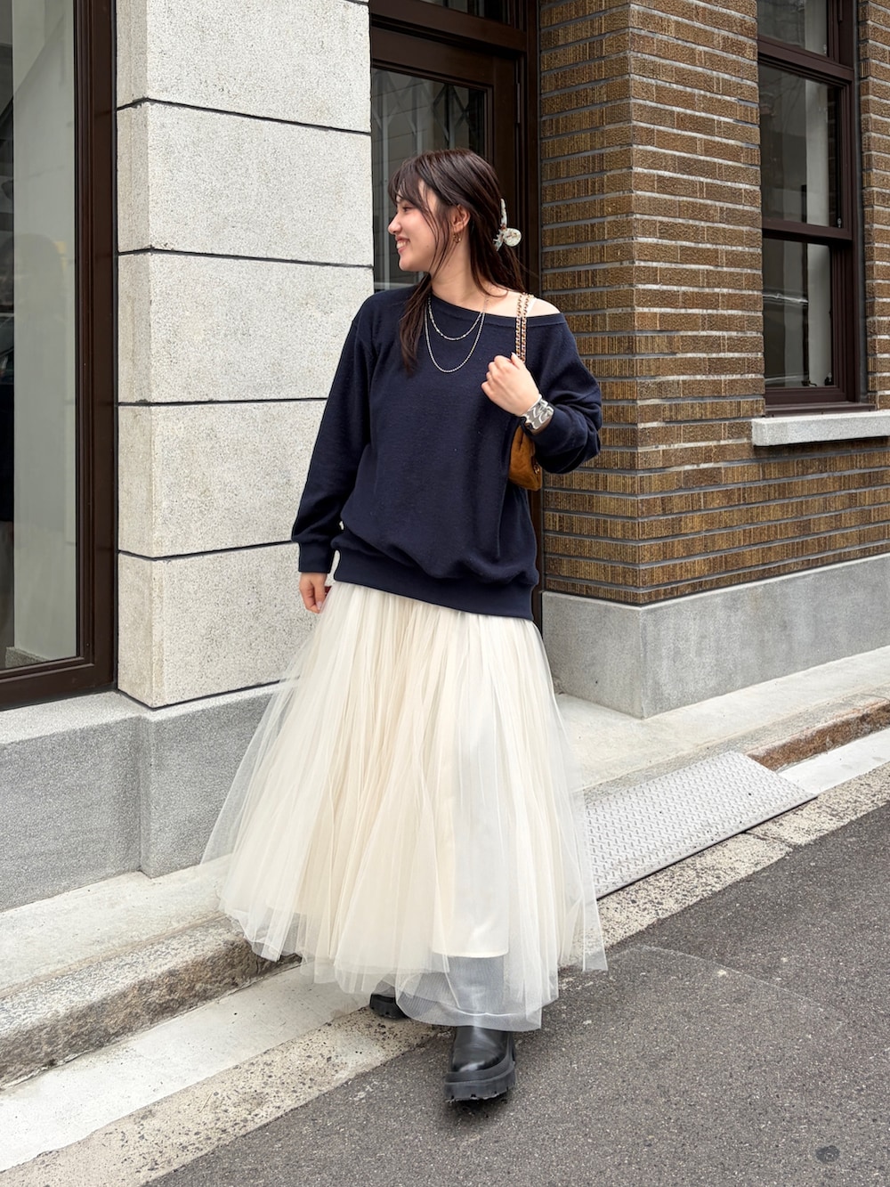 ブルー系のTシャツ/カットソー、ホワイト系のスカート、イエロー系のショルダーバッグを着用したレディースの冬コーディネートの2枚目の写真