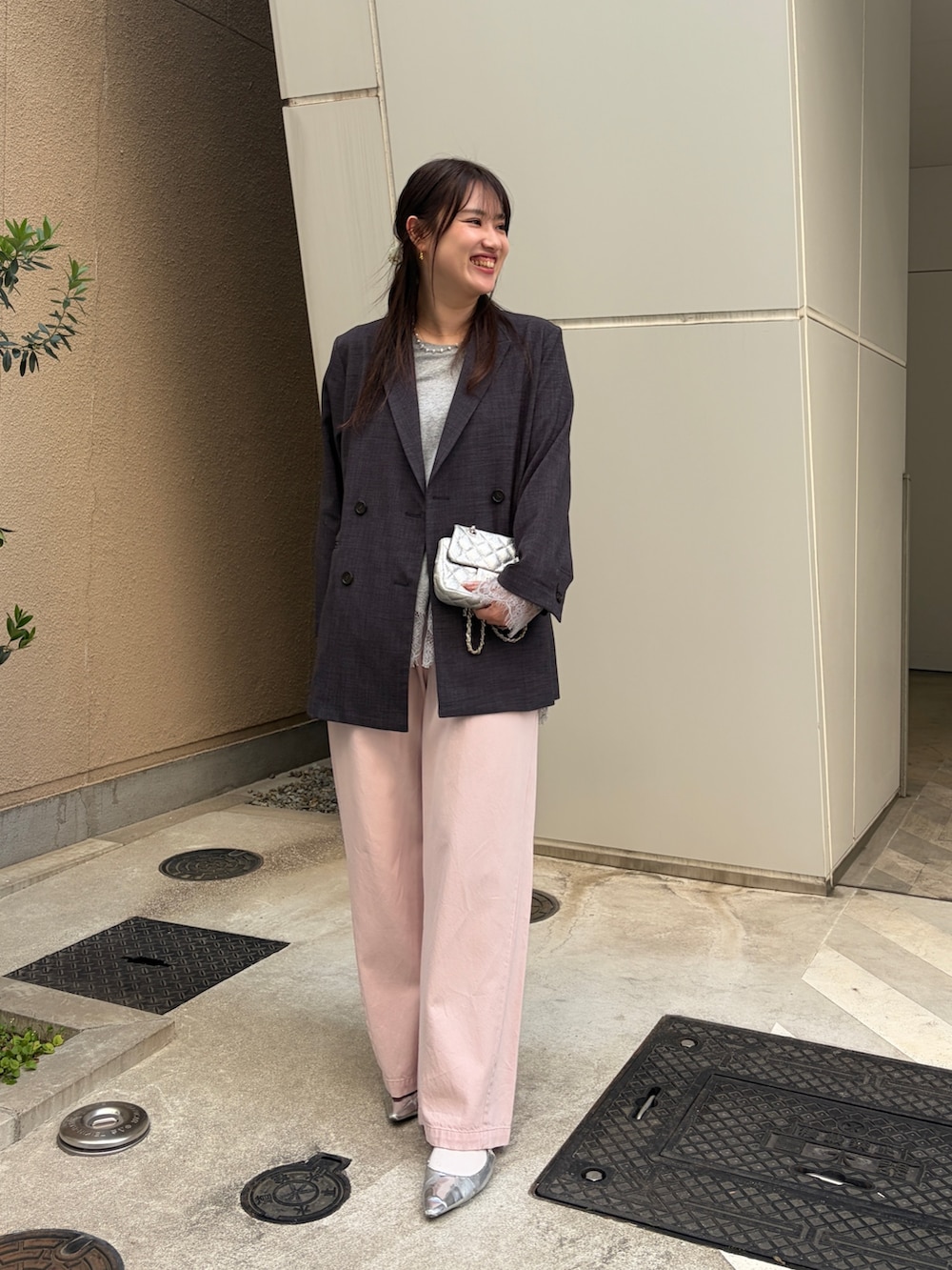 グレー系のテーラードジャケット、グレー系のTシャツ/カットソー、ピンク系のデニムパンツを着用したレディースの冬コーディネートの3枚目の写真