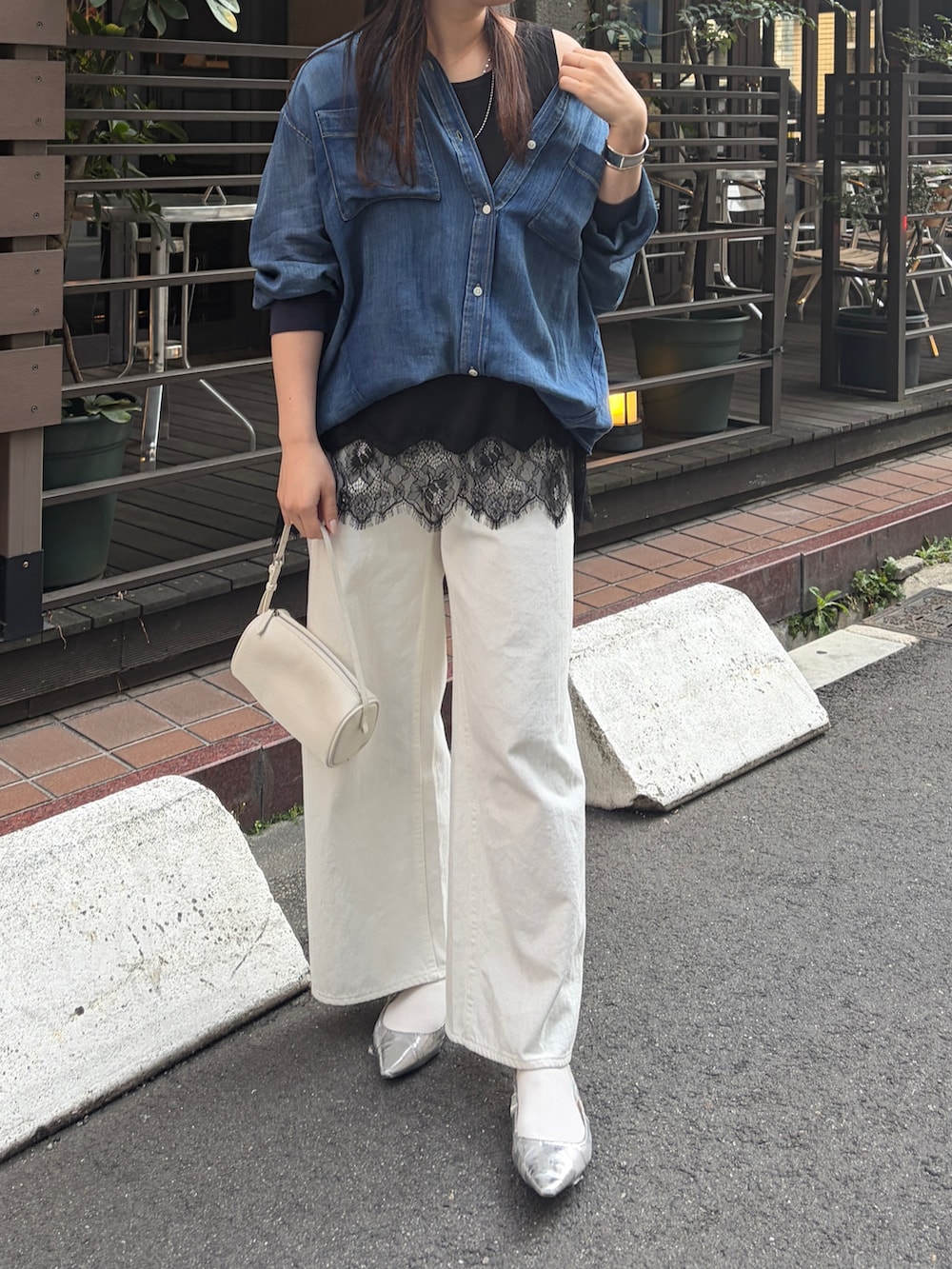 ブルー系のシャツ/ブラウス、ブラック系のTシャツ/カットソー、ホワイト系のデニムパンツを着用したレディースの春コーディネートの3枚目の写真